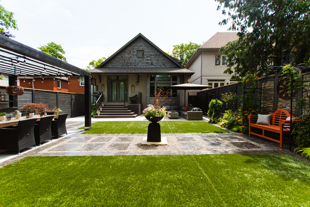 Inspiration for a large bohemian back formal partial sun garden for summer in Toronto with a fire feature and concrete paving.