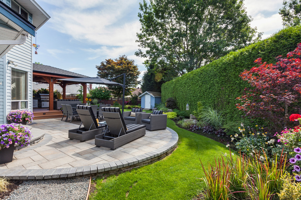Пример оригинального дизайна: огромный летний регулярный сад на заднем дворе в классическом стиле с местом для костра, полуденной тенью и покрытием из каменной брусчатки
