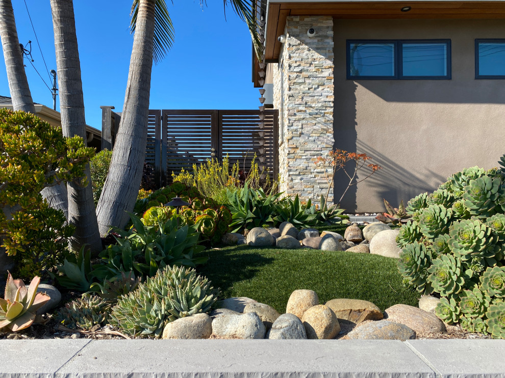 Foto di un giardino design esposto in pieno sole di medie dimensioni e davanti casa in estate con sassi di fiume e recinzione in metallo