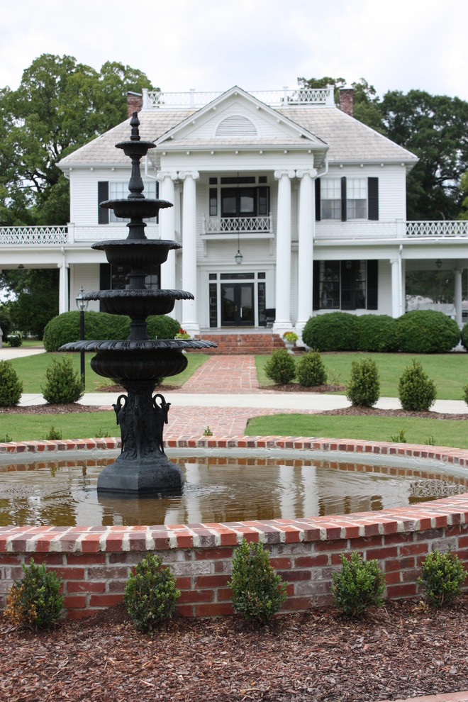 Design ideas for a classic back formal full sun garden in Jackson with a water feature and brick paving.