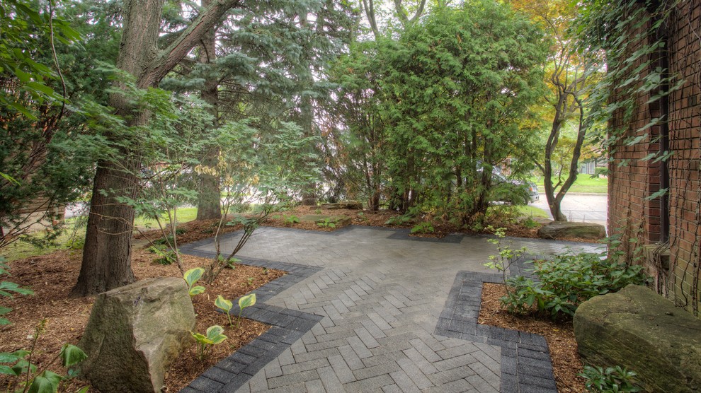 This is an example of a medium sized contemporary front driveway fully shaded garden for summer in Toronto with a garden path and brick paving.