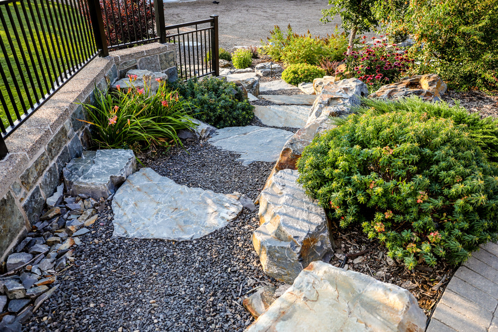 Photo of a huge traditional partial sun hillside landscaping in Calgary.