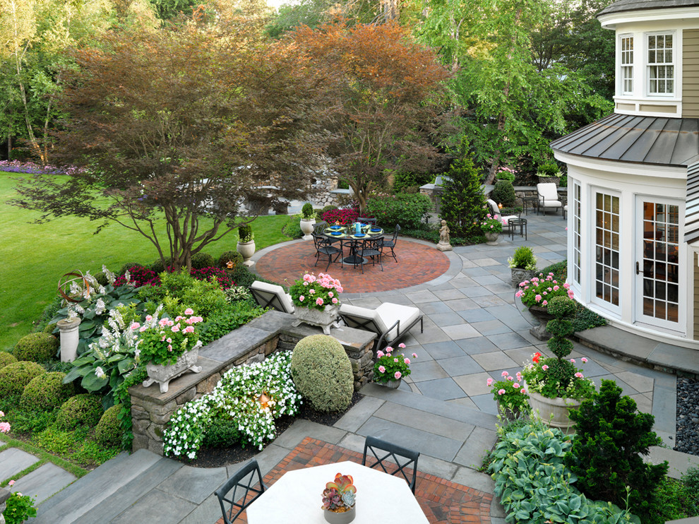 Ispirazione per un grande giardino classico esposto a mezz'ombra dietro casa con un focolare e pavimentazioni in pietra naturale