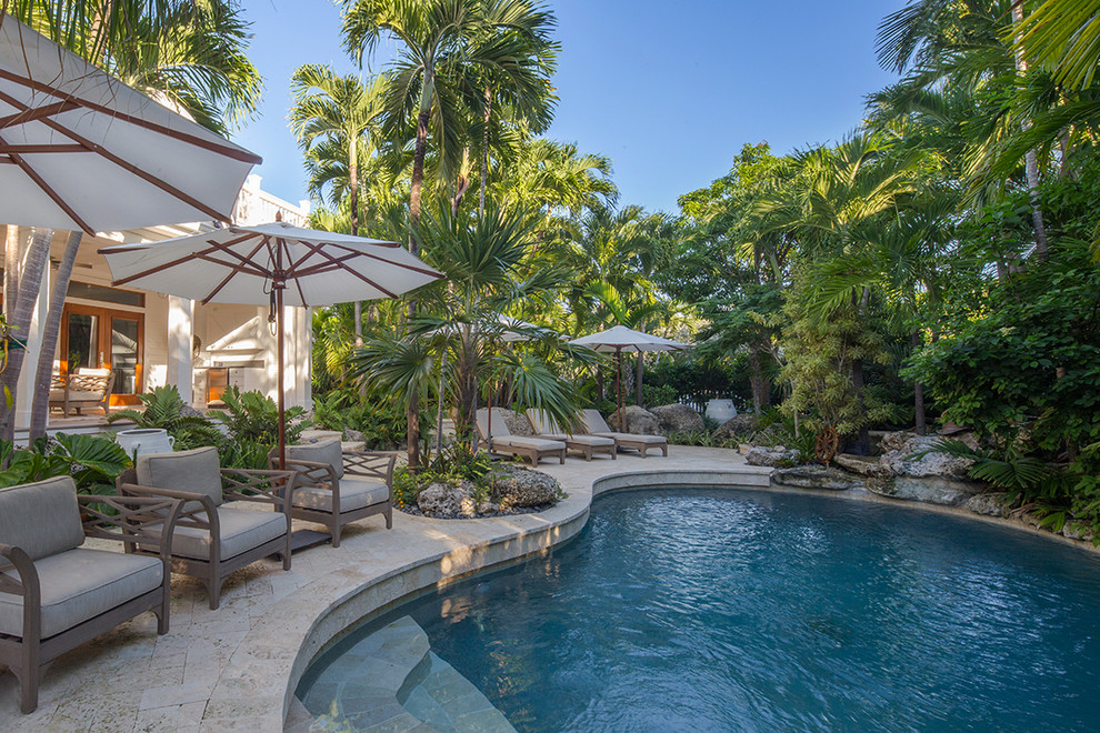 Ispirazione per una grande piscina tropicale con pavimentazioni in pietra naturale