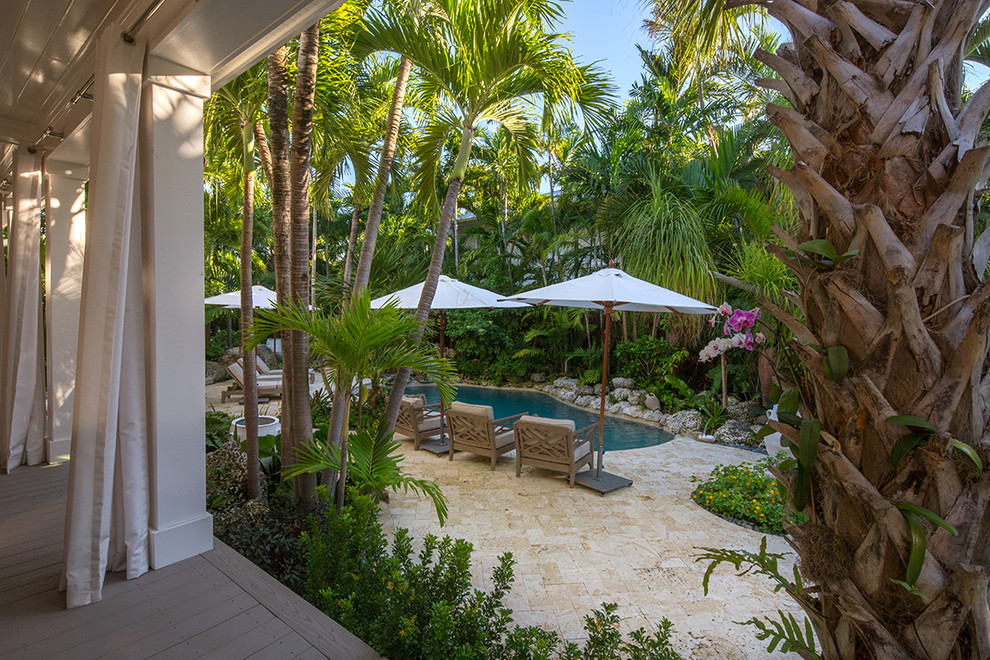 Esempio di un grande giardino tropicale nel cortile laterale con pavimentazioni in pietra naturale