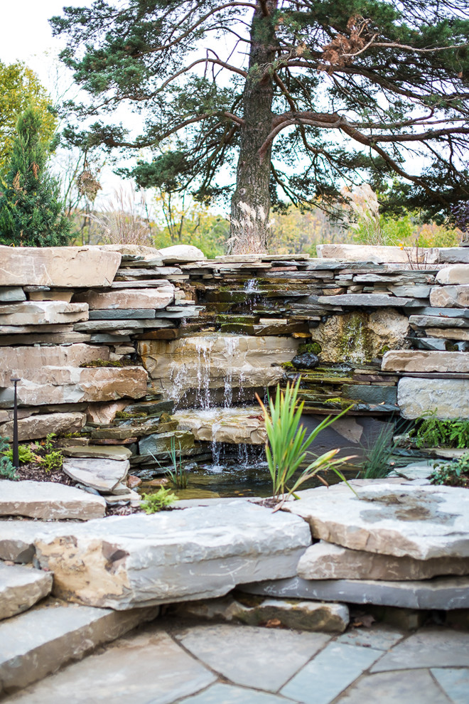 Design ideas for a large eclectic full sun backyard stone water fountain landscape in Detroit for fall.