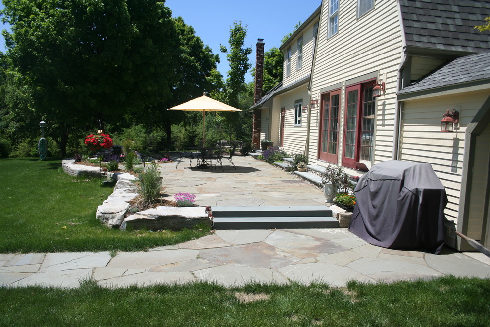 Ejemplo de jardín de estilo de casa de campo de tamaño medio en primavera en patio trasero con exposición parcial al sol, adoquines de piedra natural y fuente