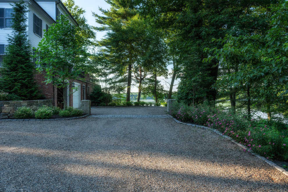 Large classic front driveway garden in Boston with a rockery and gravel.