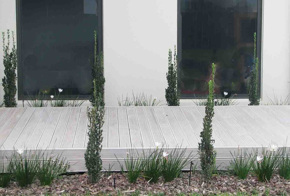Idee per un giardino minimal di medie dimensioni e davanti casa con un ingresso o sentiero e pedane