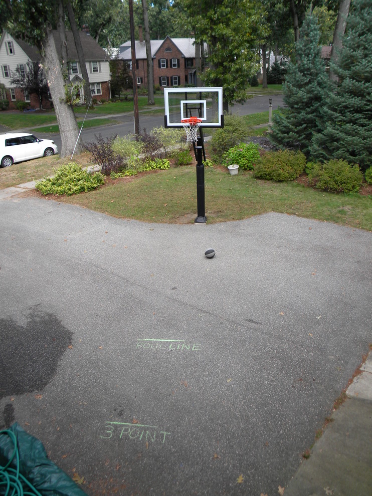 This is an example of a large traditional partial sun front yard decomposed granite outdoor sport court in Boston.