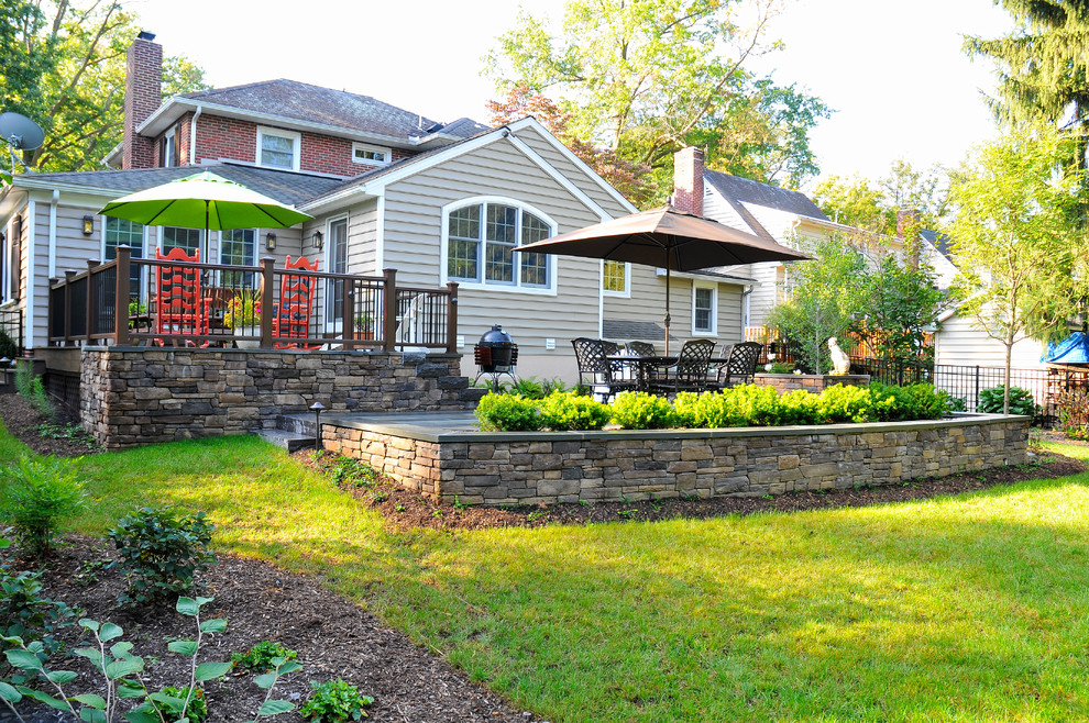 Diseño de jardín clásico en patio trasero con exposición parcial al sol y adoquines de piedra natural