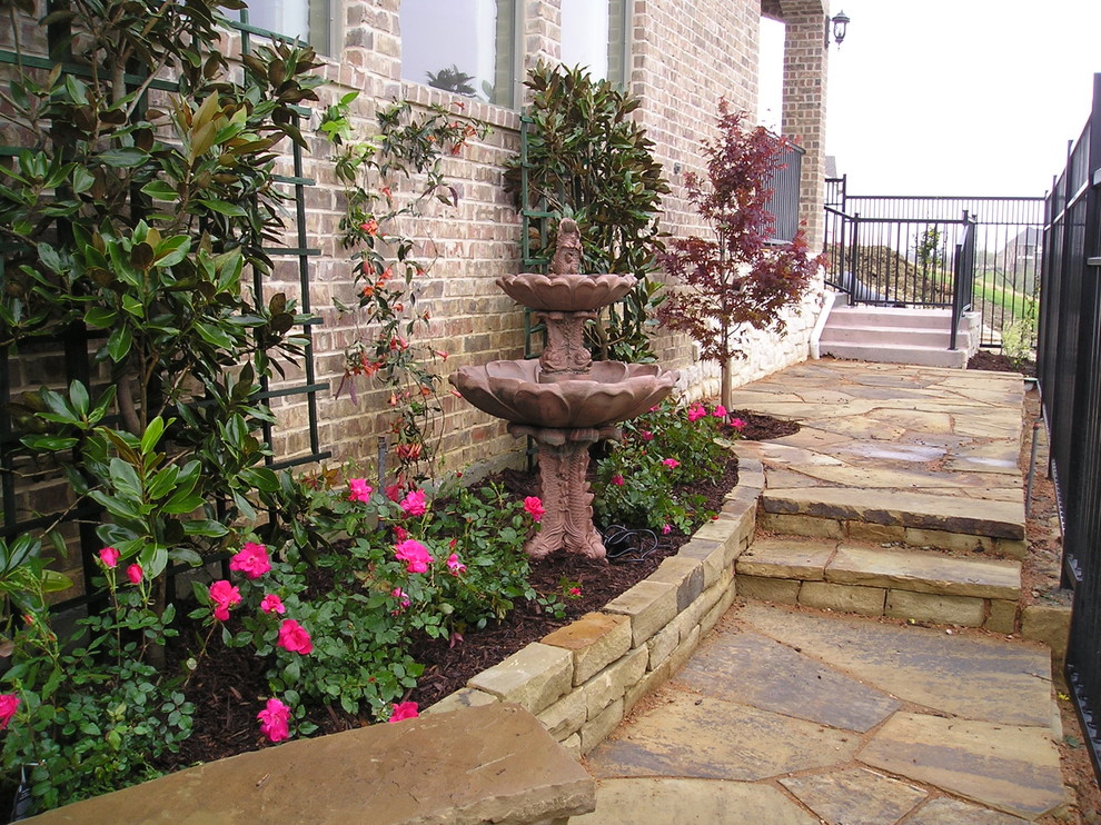 Medium sized eclectic side formal partial sun garden for spring in Dallas with a water feature and natural stone paving.