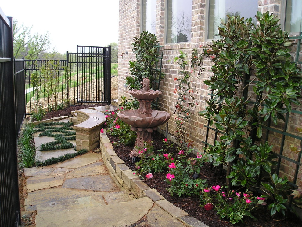 Design ideas for a medium sized classic side formal partial sun garden for spring in Dallas with a water feature and natural stone paving.