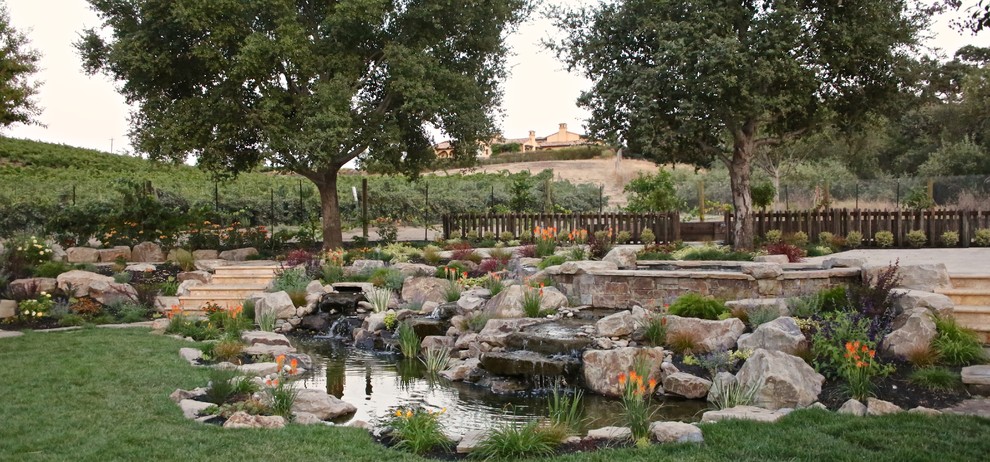 Ispirazione per un grande laghetto da giardino tradizionale esposto in pieno sole dietro casa con pavimentazioni in cemento