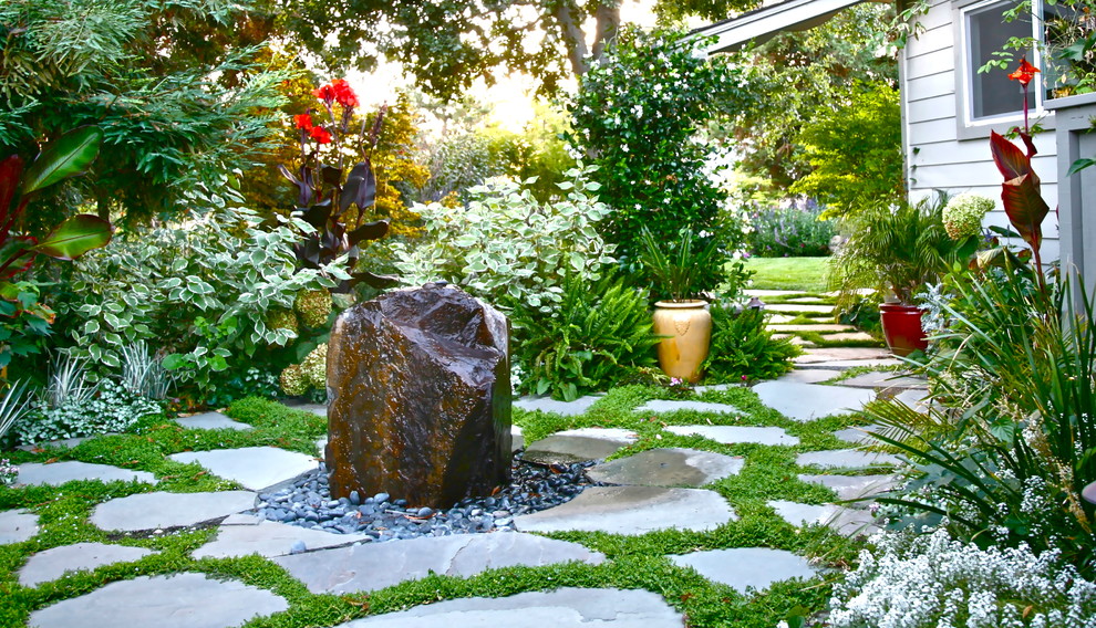 Idéer för en mellanstor klassisk trädgård i full sol längs med huset, med en trädgårdsgång och naturstensplattor