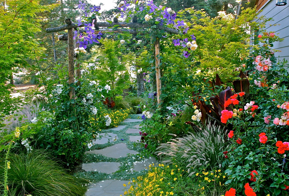 Diseño de camino de jardín clásico de tamaño medio en patio lateral con jardín francés, exposición parcial al sol y adoquines de piedra natural