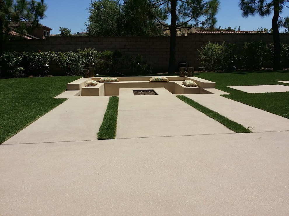 Idee per un grande giardino formale minimalista esposto in pieno sole dietro casa in estate con un focolare e pavimentazioni in cemento