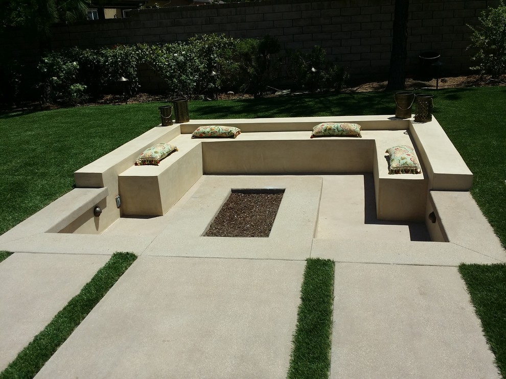 Imagen de jardín minimalista grande en verano en patio trasero con exposición total al sol, adoquines de hormigón, jardín francés y brasero