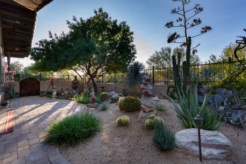 Cette image montre un petit jardin désertique arrière sud-ouest américain avec une exposition partiellement ombragée et des pavés en béton.
