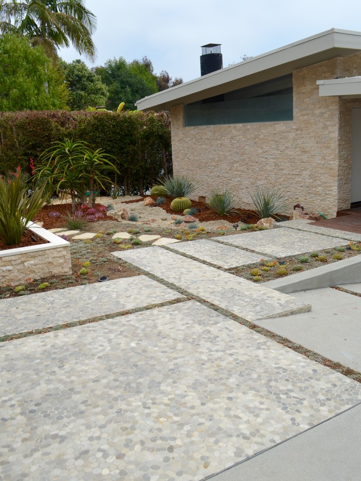 ロサンゼルスにある広いミッドセンチュリースタイルのおしゃれな前庭 (ゼリスケープ、コンクリート敷き	) の写真