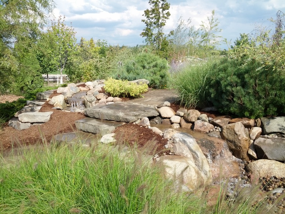 Inspiration for a huge rustic partial sun backyard mulch water fountain landscape in Detroit for summer.