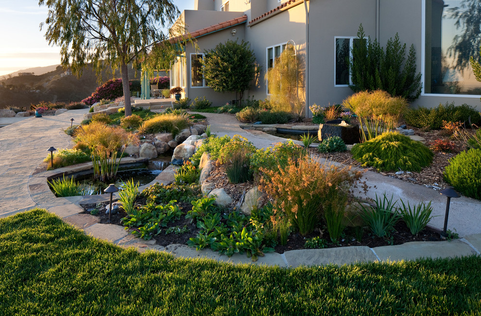 Inspiration for a large mediterranean full sun front yard stone landscaping in Santa Barbara.