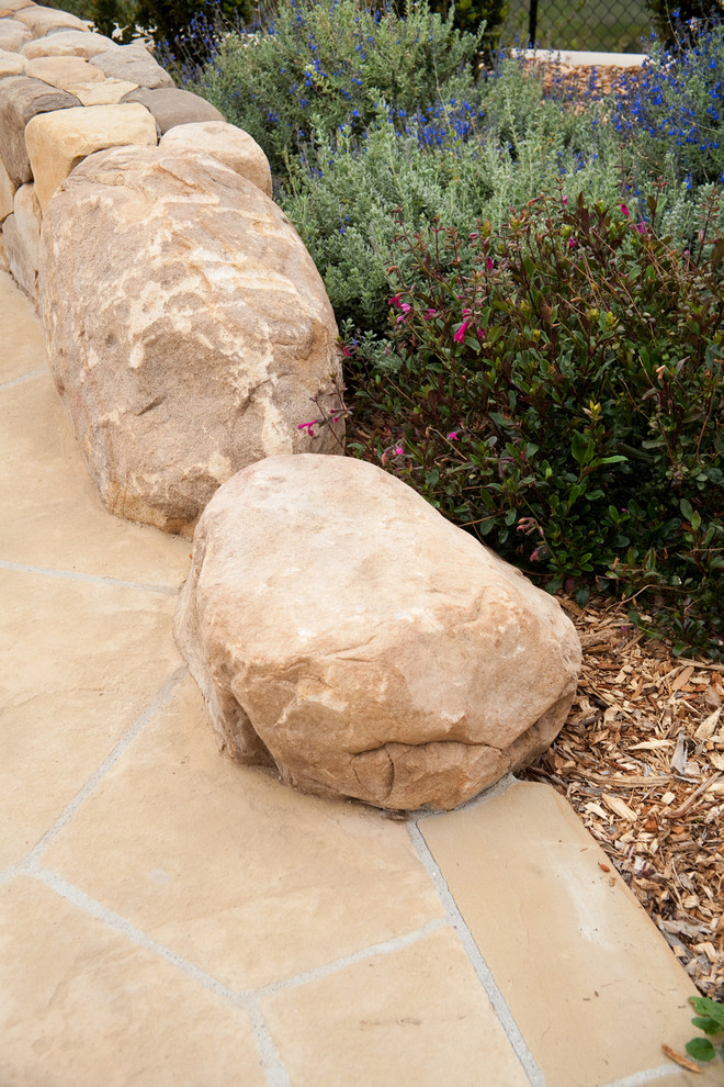 Inspiration pour un jardin méditerranéen de taille moyenne avec un mur de soutènement, une exposition ensoleillée et des pavés en pierre naturelle.