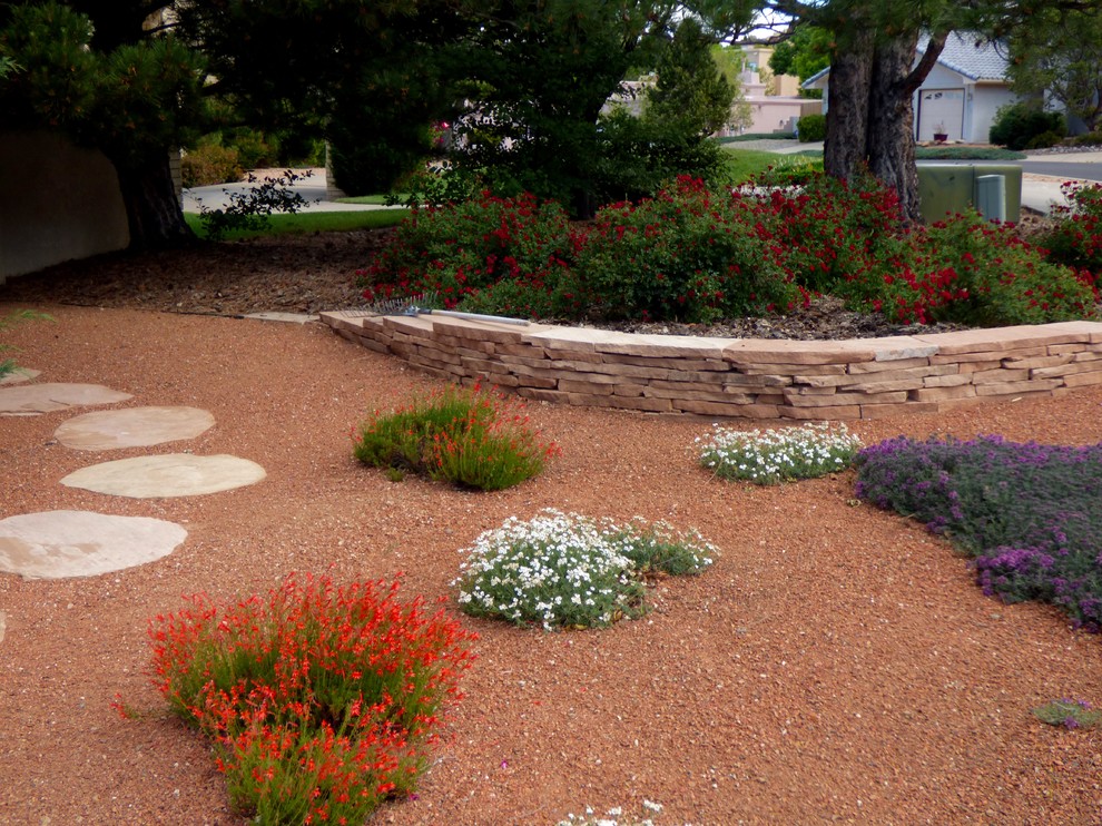 Design ideas for an eclectic drought-tolerant and full sun front yard gravel retaining wall landscape in Albuquerque for spring.