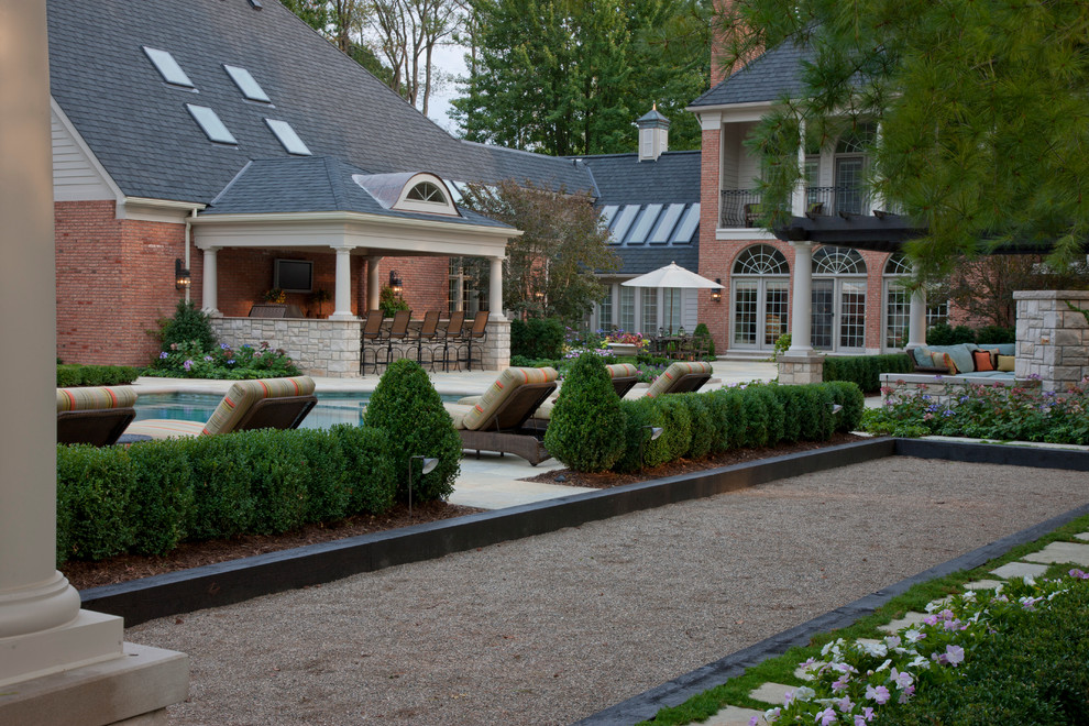 Cette image montre un grand jardin arrière traditionnel avec des pavés en pierre naturelle.