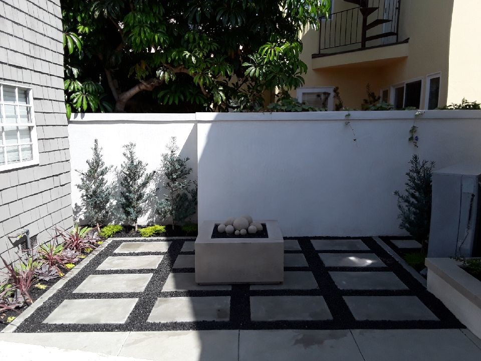 Imagen de jardín actual pequeño en patio trasero con brasero, exposición total al sol y adoquines de hormigón