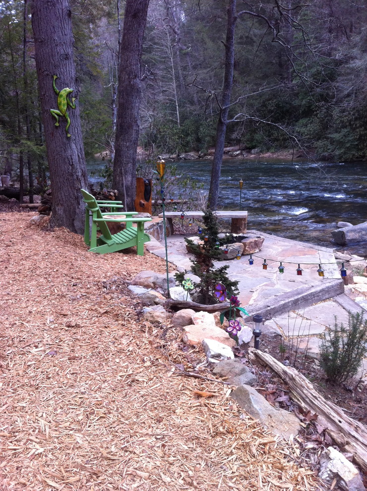 Photo of an eclectic stone landscaping with a fire pit.