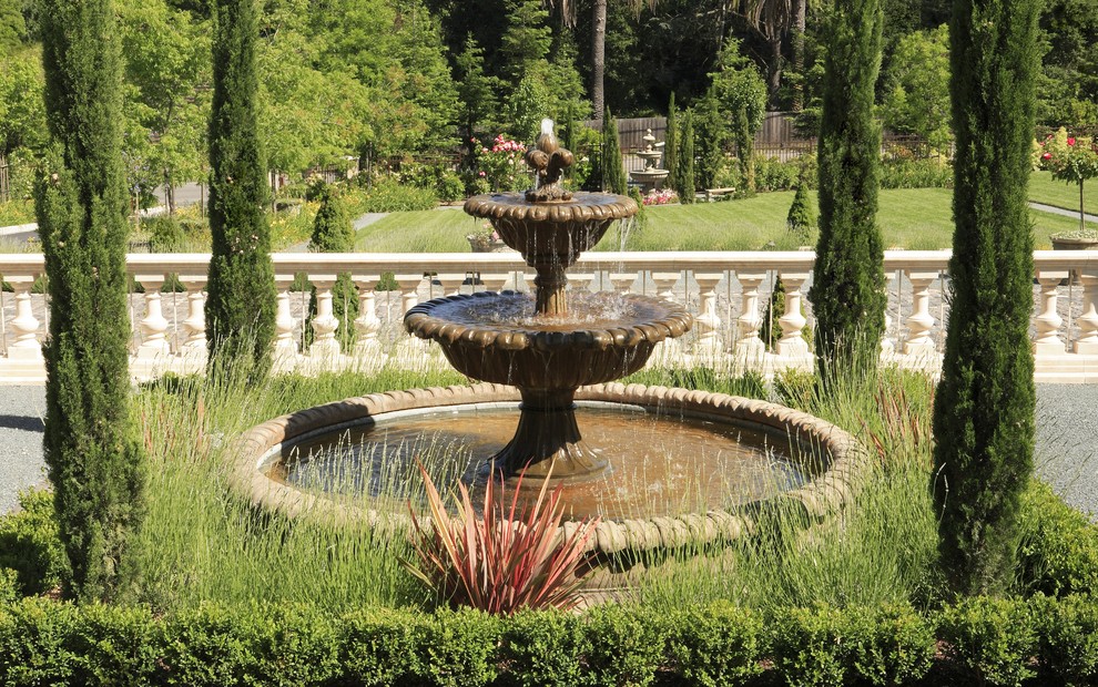 Klassisk inredning av en trädgård framför huset, med en fontän