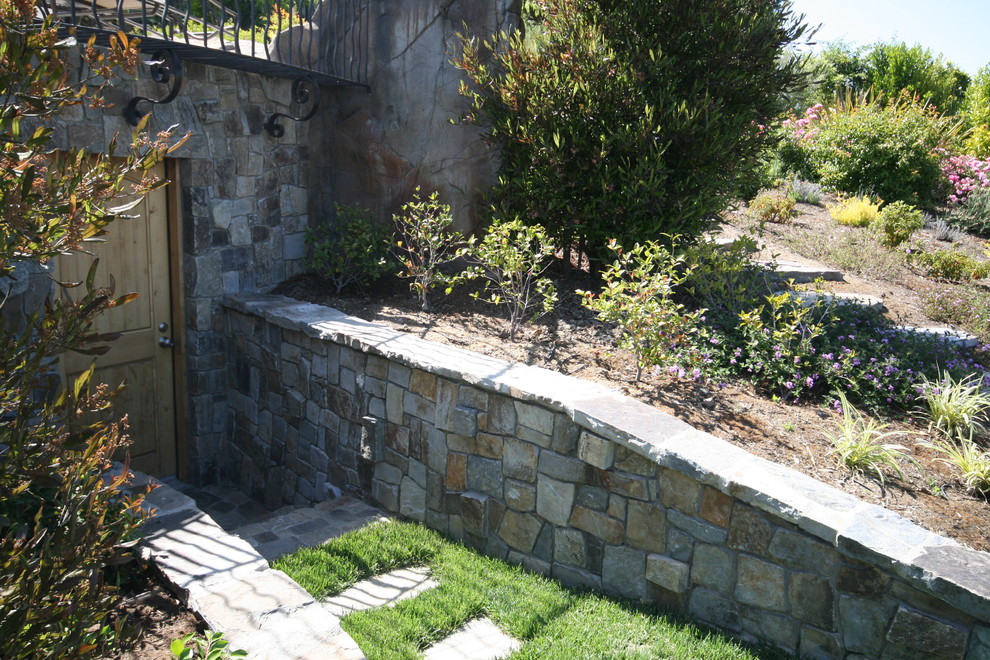Идея дизайна: большой участок и сад на заднем дворе в стиле модернизм с подпорной стенкой и покрытием из каменной брусчатки