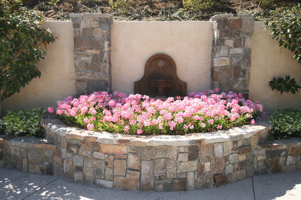 Foto de jardín mediterráneo de tamaño medio en verano con exposición parcial al sol y adoquines de piedra natural