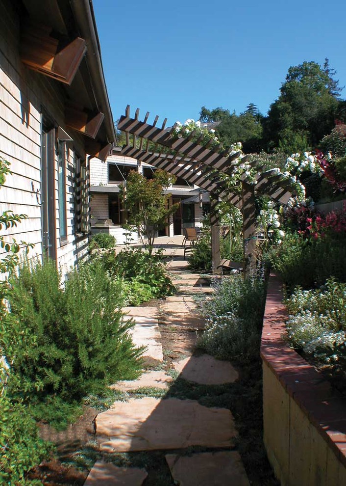 Идея дизайна: участок и сад на боковом дворе в современном стиле с подпорной стенкой