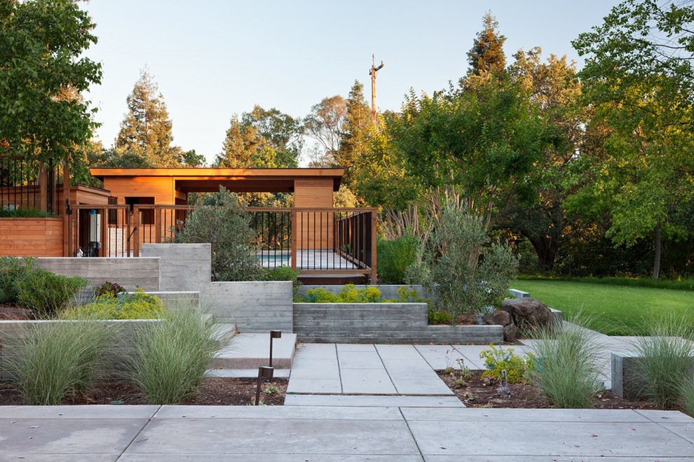Idee per un grande giardino design esposto in pieno sole dietro casa con un ingresso o sentiero e pavimentazioni in cemento