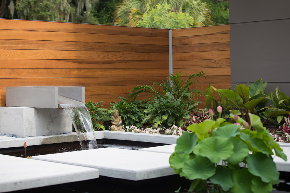 Идея дизайна: весенний садовый фонтан среднего размера на внутреннем дворе в восточном стиле с полуденной тенью, мощением тротуарной плиткой и с деревянным забором