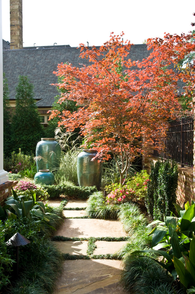 Diseño de jardín clásico grande en verano en patio lateral con fuente, exposición parcial al sol y adoquines de piedra natural