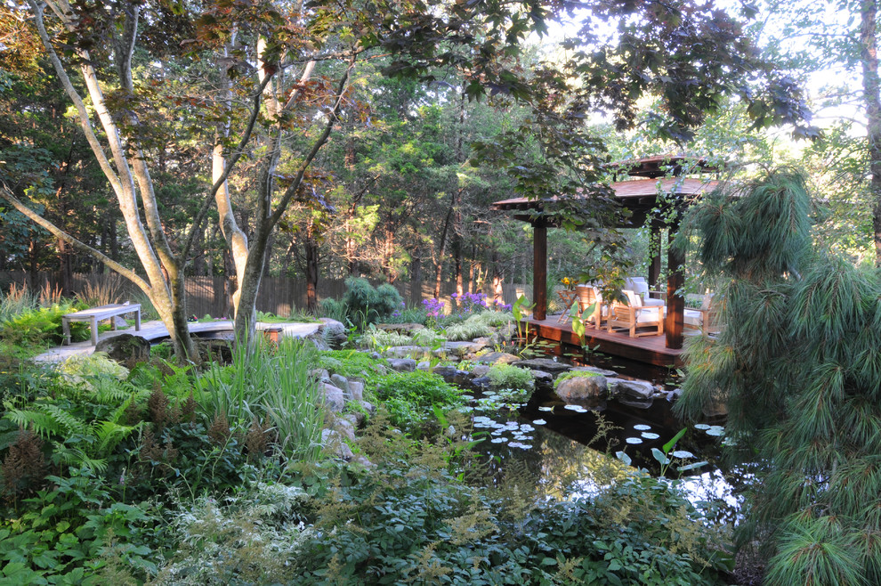 Inspiration för en mellanstor orientalisk bakgård i delvis sol, med en damm och trädäck