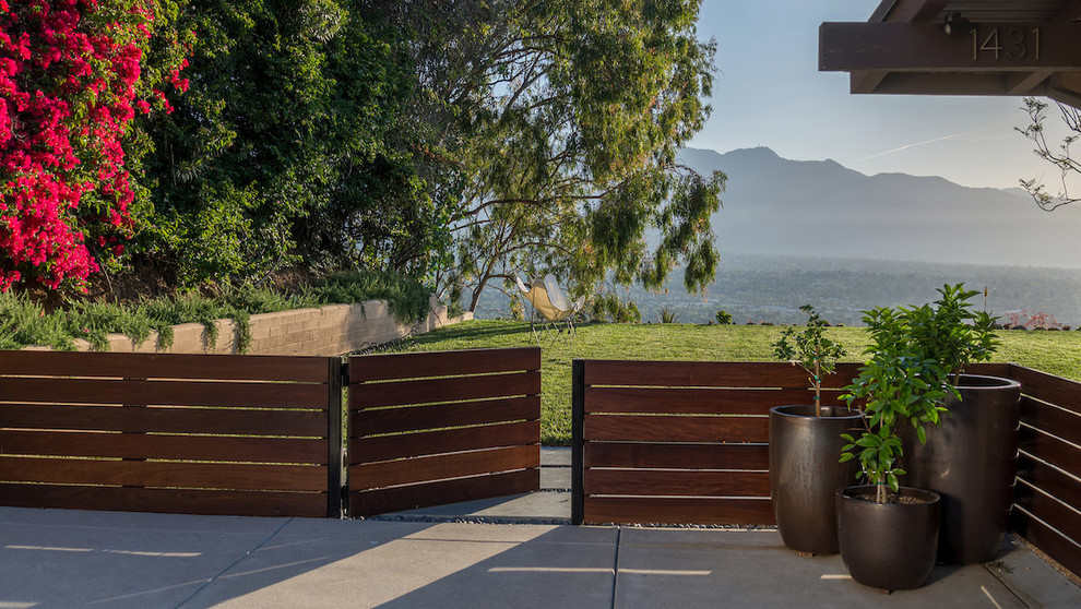 Diseño de jardín moderno grande en patio trasero con exposición total al sol y portón