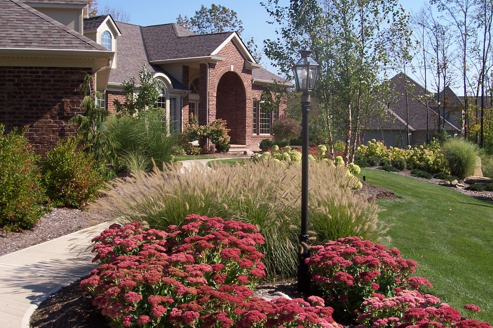 Esempio di un ampio giardino tradizionale esposto in pieno sole davanti casa in autunno con un ingresso o sentiero e pavimentazioni in cemento