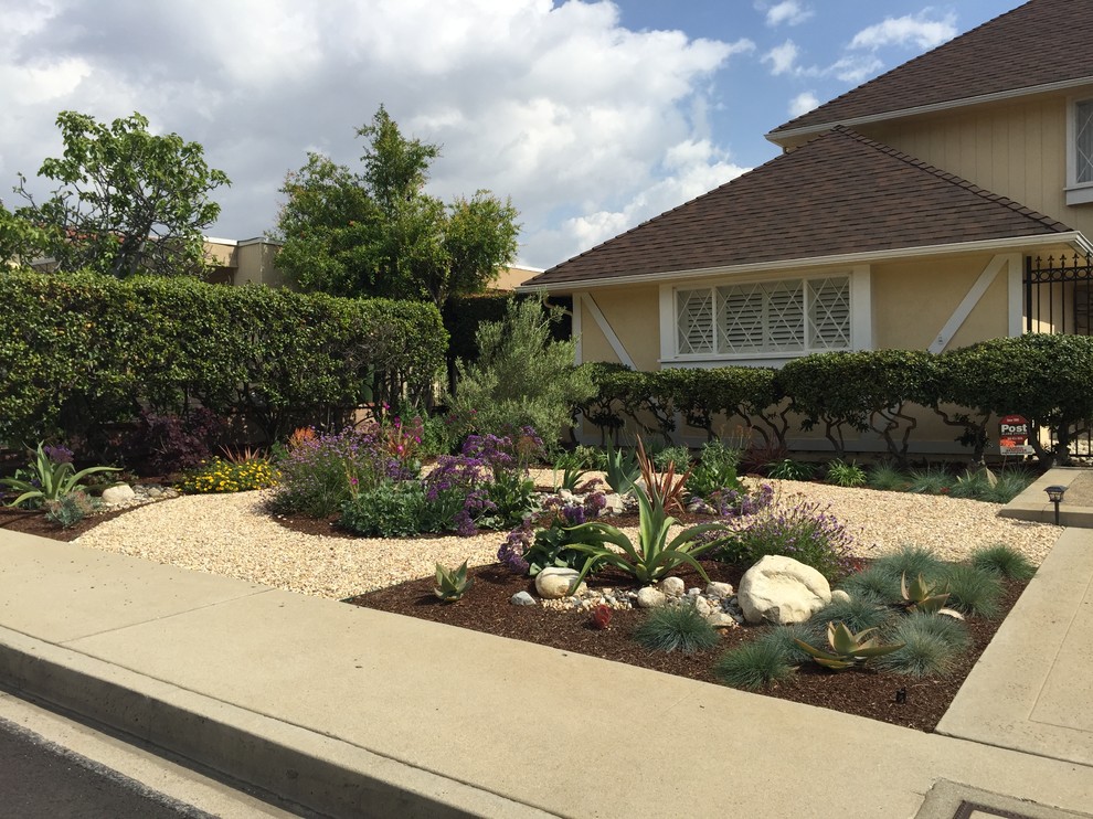 Large retro front xeriscape full sun garden in Los Angeles with gravel.