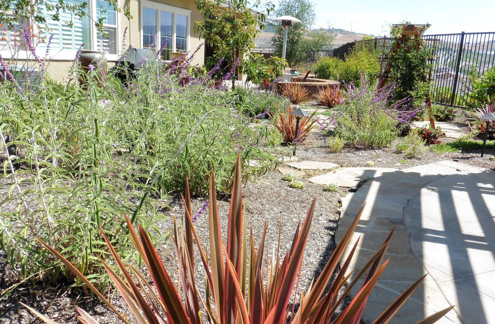 Inspiration pour un grand jardin arrière traditionnel l'été avec une exposition ensoleillée et des pavés en pierre naturelle.