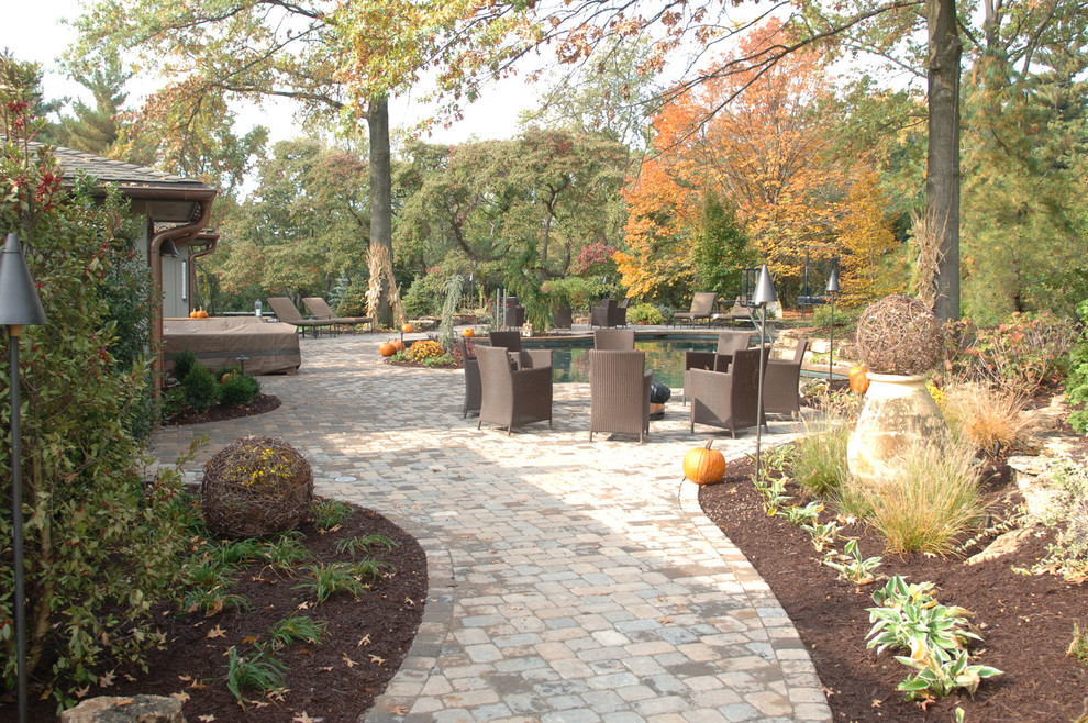 Photo of a large traditional full sun backyard brick water fountain landscape in St Louis for fall.