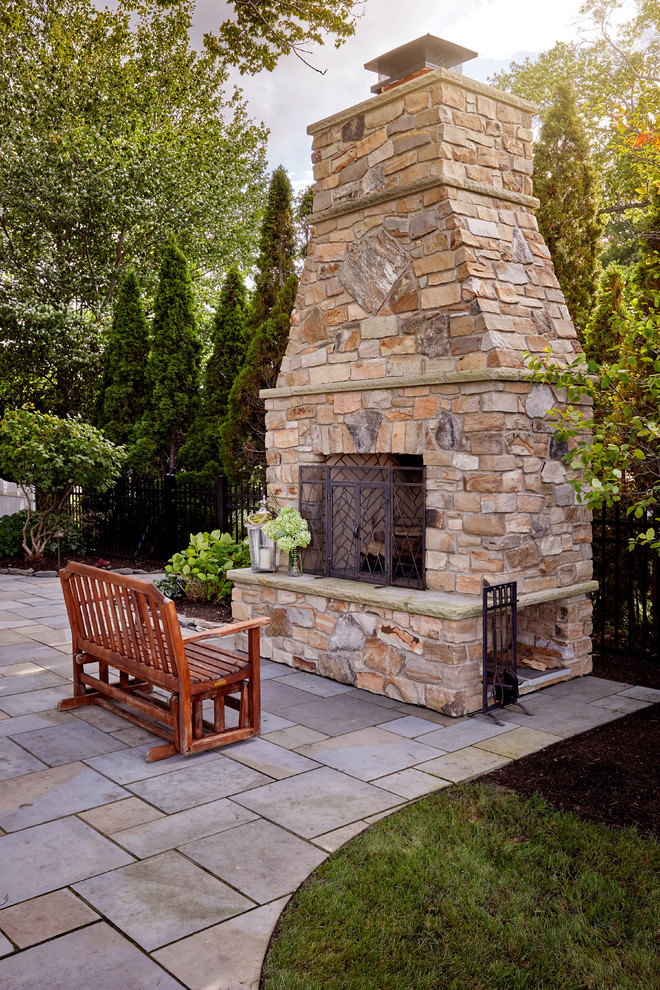 Ispirazione per un grande patio o portico stile americano dietro casa con un caminetto e pavimentazioni in pietra naturale