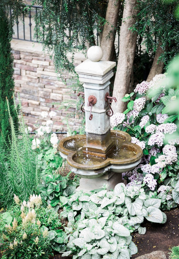 Foto di un grande giardino formale chic esposto in pieno sole dietro casa in primavera con fontane e pavimentazioni in pietra naturale
