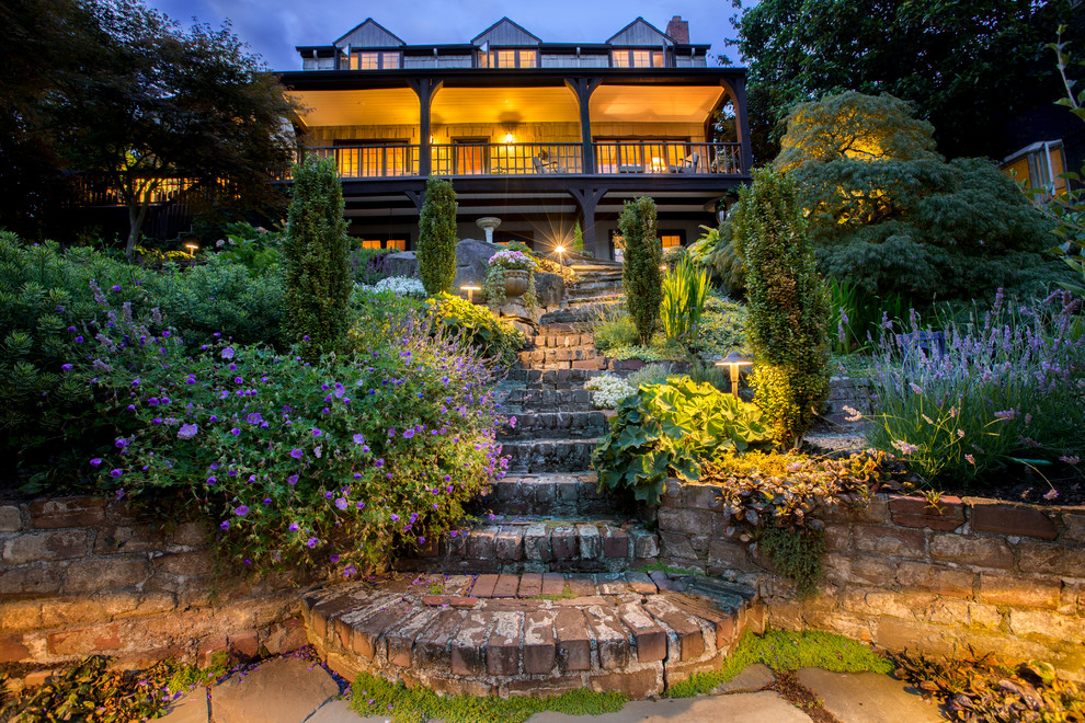Пример оригинального дизайна: большой солнечный, весенний регулярный сад на заднем дворе в классическом стиле с хорошей освещенностью, мощением клинкерной брусчаткой и садовой дорожкой или калиткой