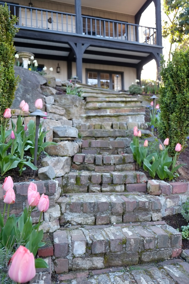 Esempio di un grande giardino formale classico esposto in pieno sole dietro casa in primavera con pavimentazioni in mattoni e un ingresso o sentiero