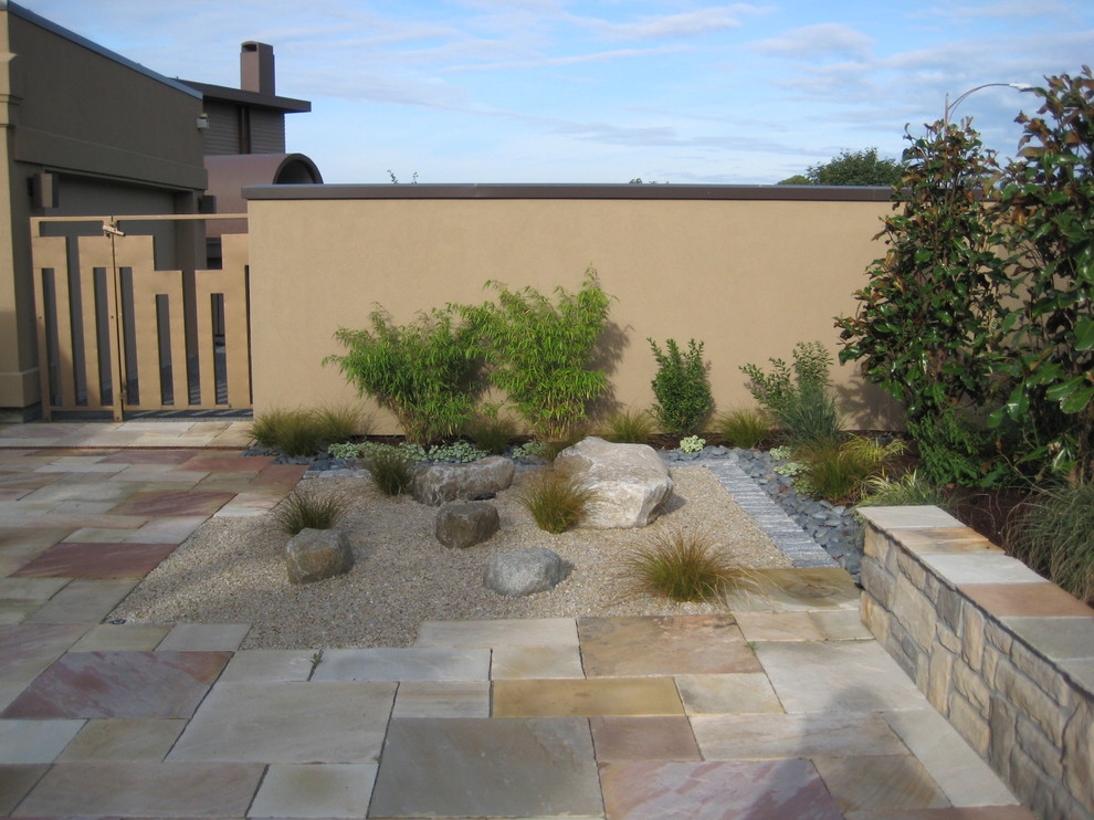 Foto de jardín minimalista de tamaño medio en patio con exposición total al sol y adoquines de piedra natural