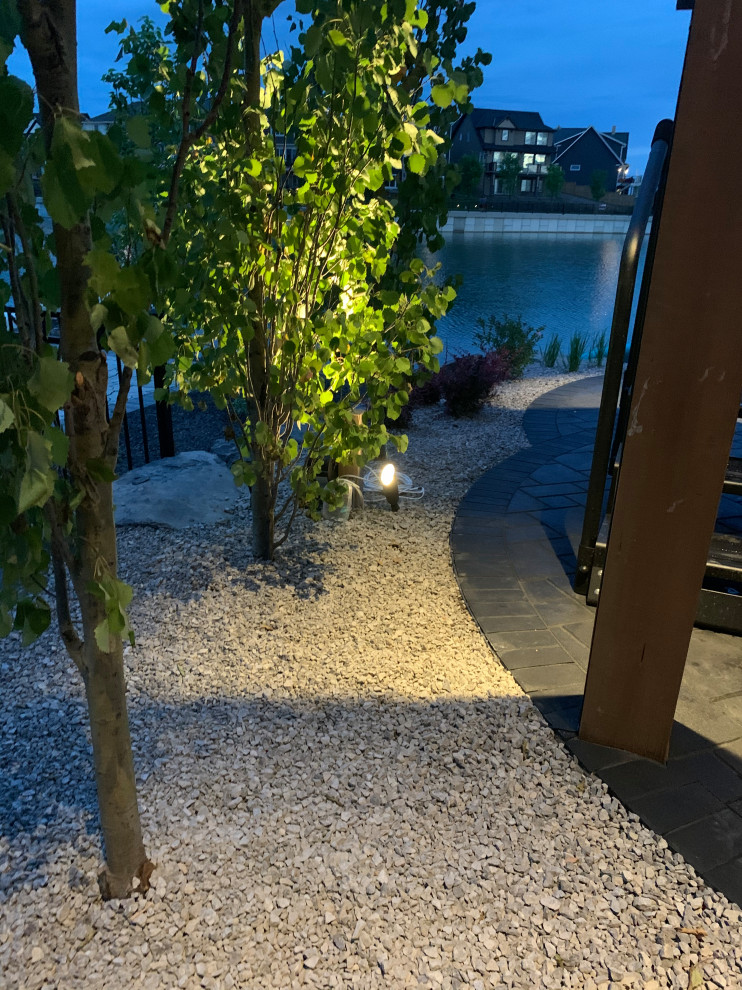 Immagine di un grande giardino costiero esposto in pieno sole nel cortile laterale con graniglia di granito